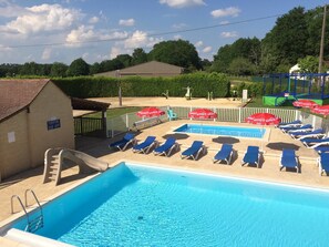 Een seizoensgebonden buitenzwembad, parasols voor strand/zwembad