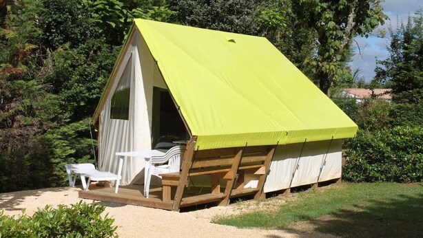 A small, single-room tent with a bright green roof, white walls, and a wooden floor. There are two white plastic chairs outside the tent. - Camping Les Poutiroux - Tente Lodge (Limeuil)