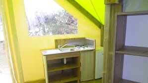 A compact kitchen with a sink, stove, and a small refrigerator. - Camping Les Poutiroux - Tente Lodge (Limeuil)