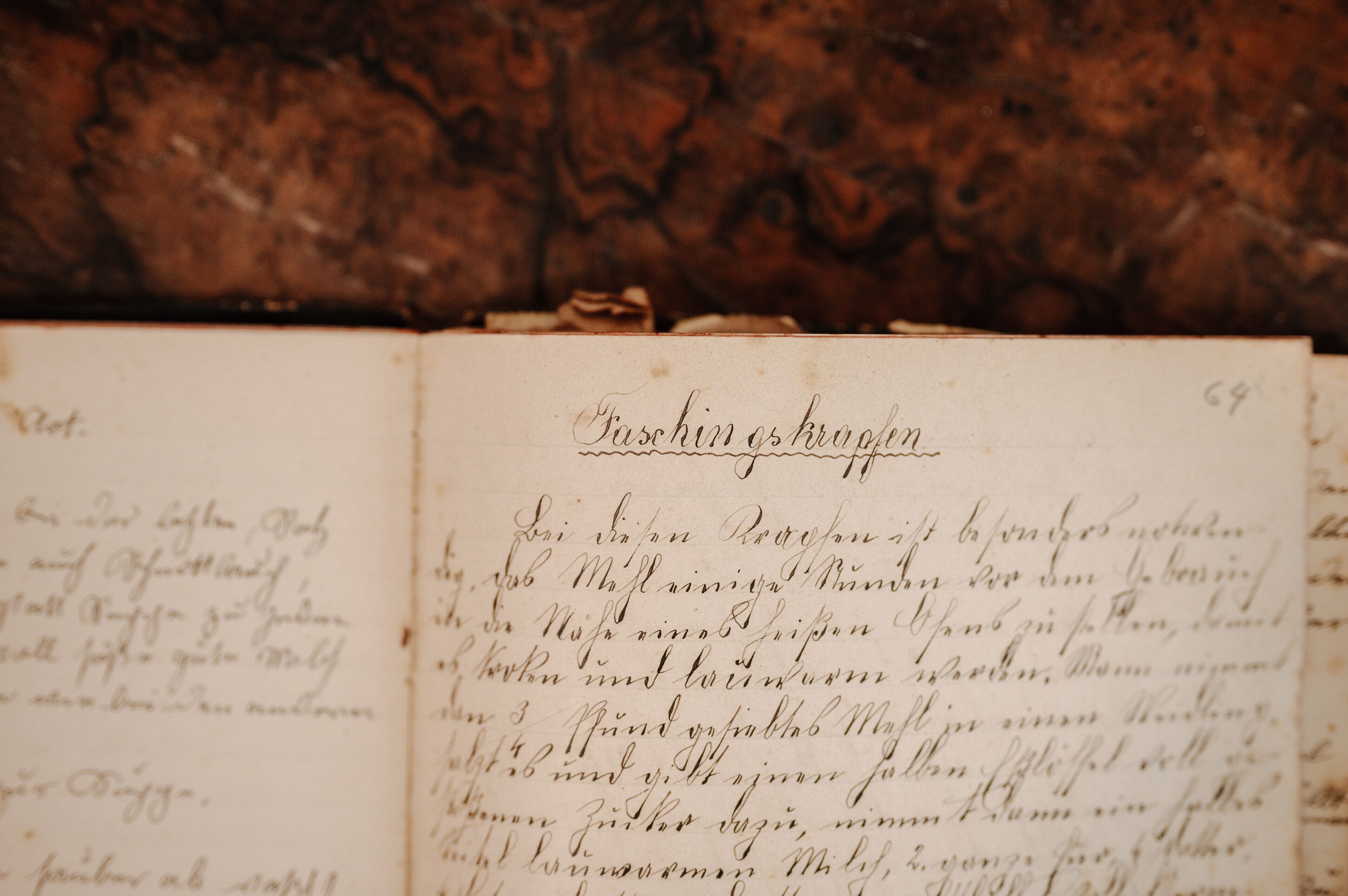 Un libro abierto con texto manuscrito en papel envejecido, con un título en la parte superior.
