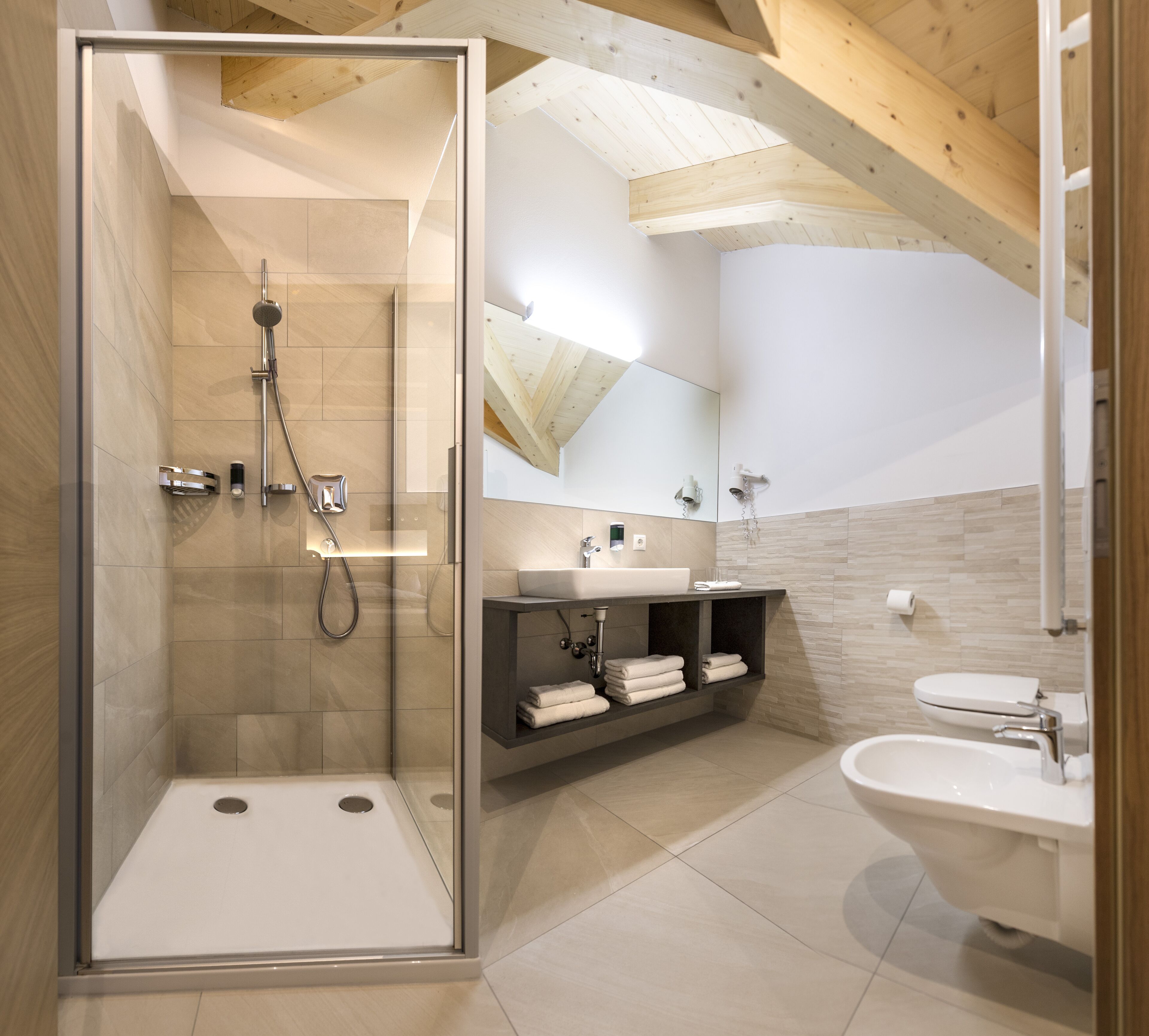 A modern bathroom with a glass-enclosed shower, a vanity with a sink, and a toilet.