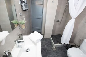 Ein modernes Badezimmer mit einem großen weißen Waschbecken, einer Toilette und einer Duschkabine.
