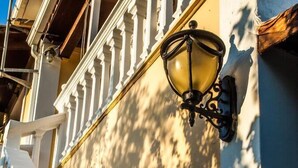 Una escalera con balaustradas blancas y una lámpara fijada a la pared.