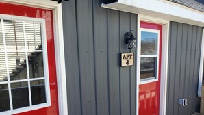 A building with a red door and a window with white shutters.