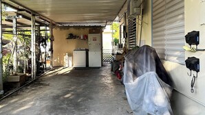 A covered outdoor area with a concrete floor, a white washing machine, and a covered motorcycle. - A second story house at less than 5 min walking from beach (Aguada)