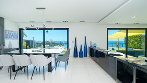 Un espace de restauration moderne avec vue sur la mer, une grande fenêtre et un design minimaliste.