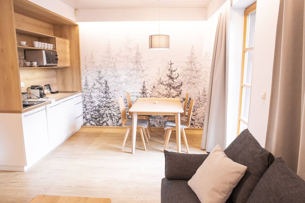 Een gezellige, compacte ruimte met een kitchenette, een eethoek en zitplaatsen.