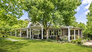 A house with a covered porch, a lawn, and trees. - One Bedroom Cottage with a Shared Pool (Dural)