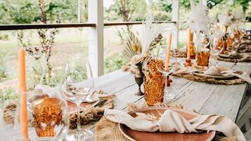 Una larga mesa dispuesta con cristalería, velas y decoración rústica.