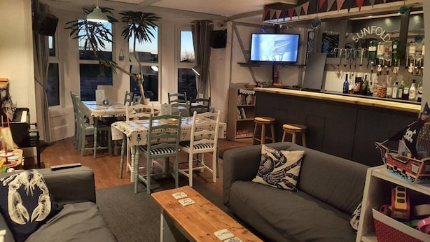 A cozy living room with a bar area, a dining table, and a sofa. - The Sunfold (Weston-super-Mare)