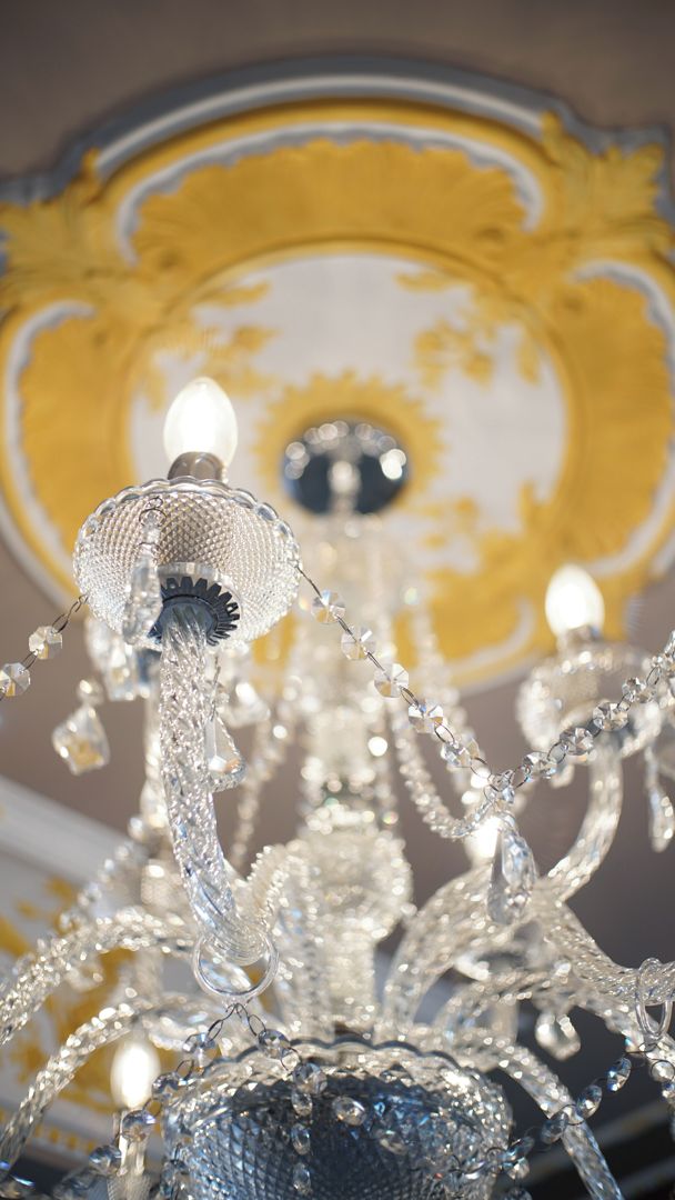A chandelier with crystal elements and a decorative ceiling.