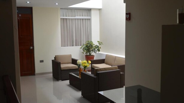 A modern living room with two sofas, a coffee table, and a potted plant. - Mística Boutique Hotel (Arequipa)