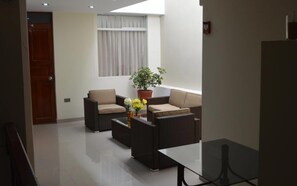 A modern living room with two sofas, a coffee table, and a potted plant. - Mística Boutique Hotel (Arequipa)