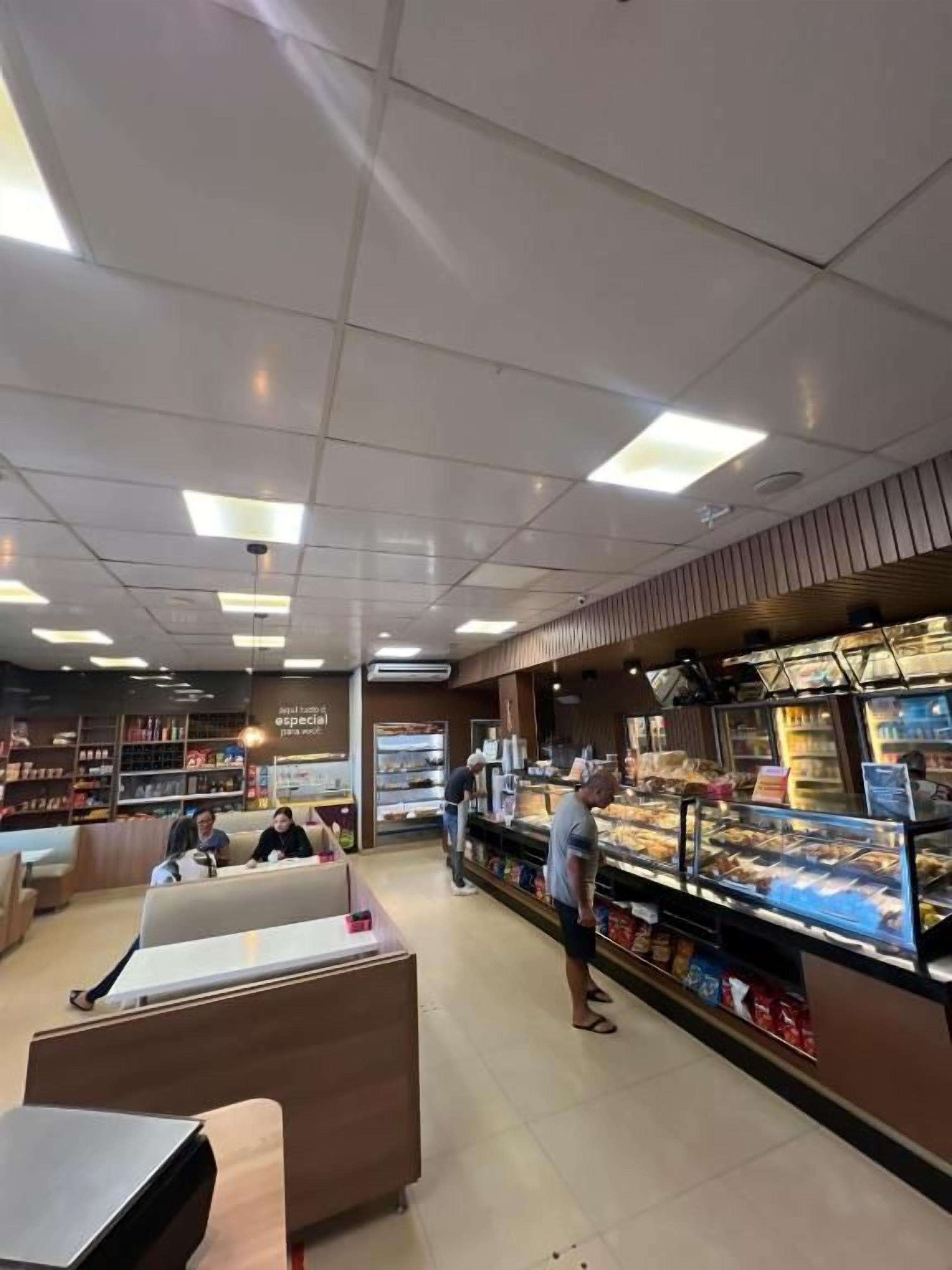 Una panadería con vitrina de productos horneados, zona de estar y mostrador para ordenar.