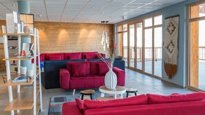 Un intérieur moderne avec un canapé rouge, un canapé bleu et une table basse blanche.