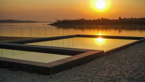 A rectangular pool with clear water, surrounded by a sandy beach and a fence. - The Anchorage (Vaal Marina)
