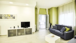 A living room with a grey sofa, a white coffee table, and a TV on a white cabinet. - Casa Primavera with shared pool - My Rental Homes (Sorrento)