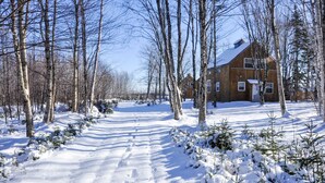 A snow-covered landscape with a wooden cabin and a clear sky.