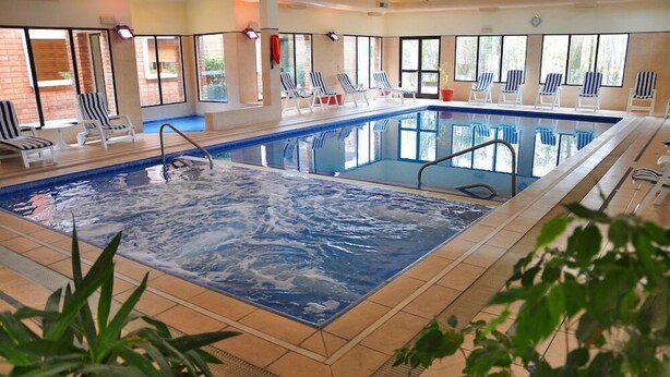 An indoor swimming pool with lounge chairs and a hot tub area. - EL MIRADOR HOTEL SPA (Colonia del Sacramento)
