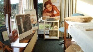 A hotel room with a bed, a small desk, and a window with a view of greenery outside. - EL MIRADOR HOTEL SPA (Colonia del Sacramento)