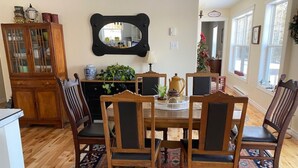 A dining area with a wooden table, chairs, a rug, a mirror, and a cabinet. - Beautiful water's edge 2 bedroom vacation home (Breadalbane)