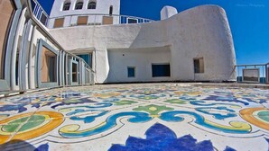 Ein Gebäude mit weißer Fassade und einem gemusterten Boden.