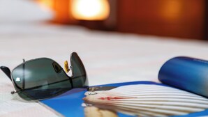 Sunglasses and a rolled-up item on a surface. - Hotel Praia Sol (Serra)
