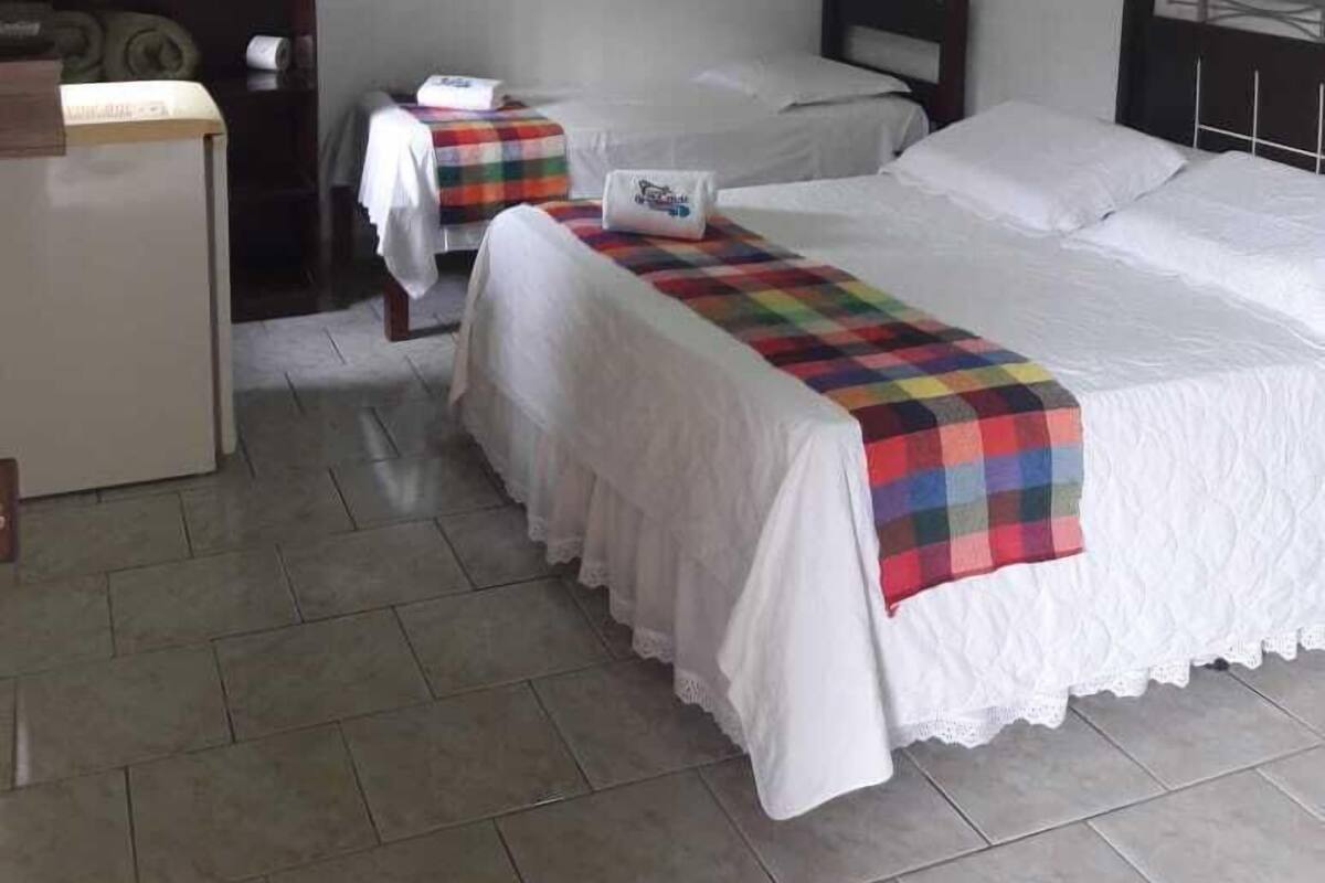 A hotel room with two beds, a desk, and a chair.