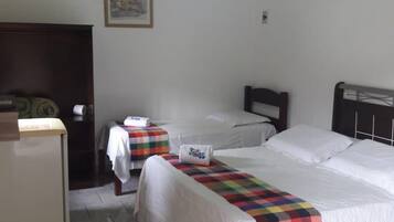 Quarto de hotel com duas camas, uma escrivaninha e uma cadeira.