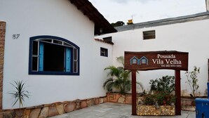 A building with a sign reading "Pousada Vila Velha" and a number "57" on the wall. - Pousada Vila Velha (Pirenópolis)