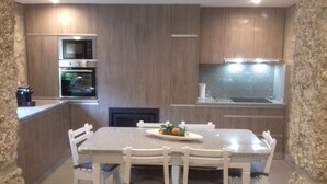Una cocina moderna con encimera de granito, armarios blancos y horno empotrado.