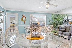 Relax in this stylish living area with a round table, comfortable sofa, and lush greenery.
