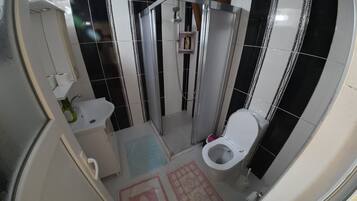 Un baño con inodoro, lavamanos y ducha.