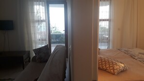 A room with a bed, a sofa, and a television on the wall. - Ozcan Apart Pansiyon (Sinop)