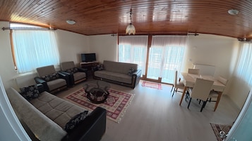 Una sala de estar con un sofá, una mesa de centro y un televisor.