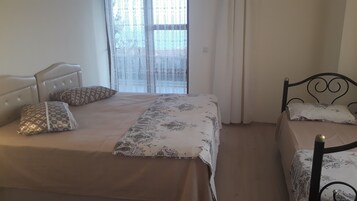 A bedroom with two beds, one with a headboard and the other with a metal frame.