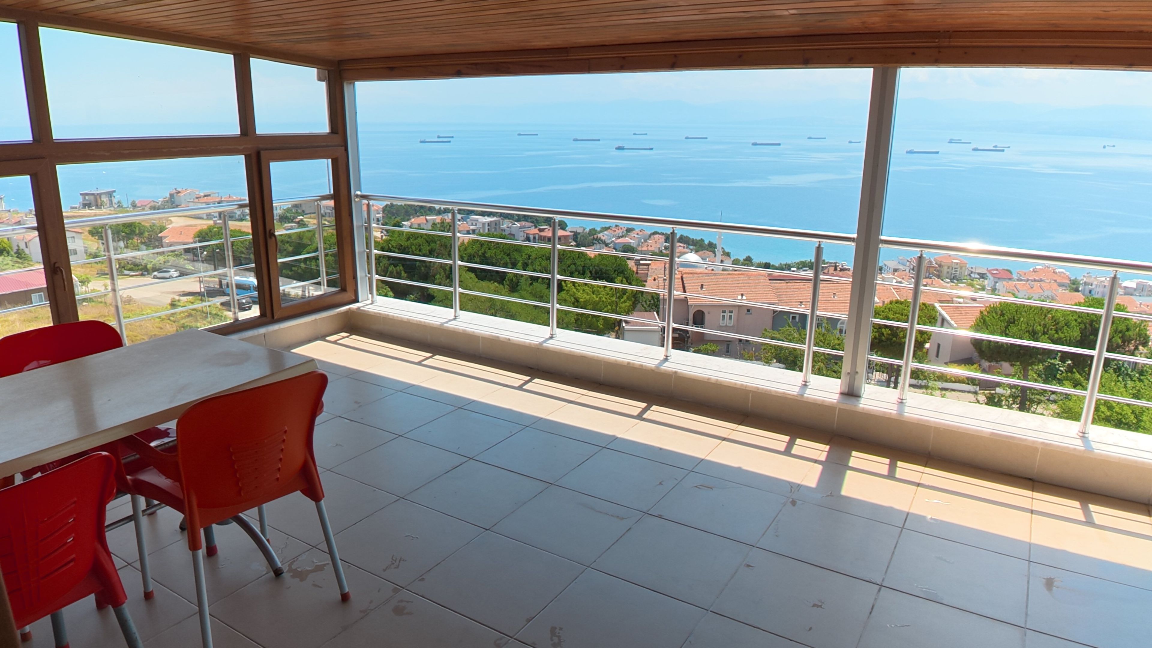 A balcony with a view of the sea and buildings.