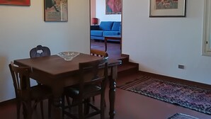 En matplats med ett träbord och stolar, en mönstrad matta och konstverk på väggarna.