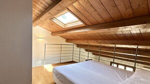 A bedroom with a bunk bed, skylight, wooden ceiling beams, and a metal railing. - S171 - Sirolo, wonderful studio in the center (Sirolo)