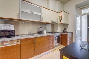 A modern kitchen with a Bosch microwave, sink, and stove, wooden cabinets, and a window.