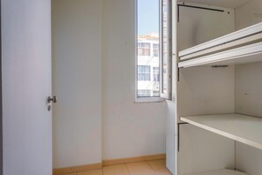 Quarto com porta, janela e estante embutida.
