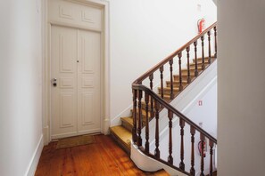 Una escalera con barandillas de madera y una puerta blanca con picaporte.