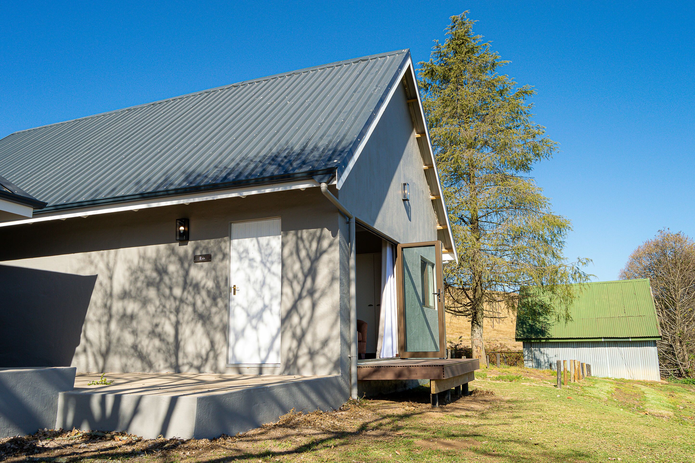 A modern building with a sloped roof, a porch, and a small deck.
