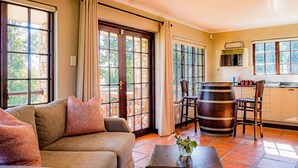A spacious living room with a sofa, a coffee table, and a large window with curtains.