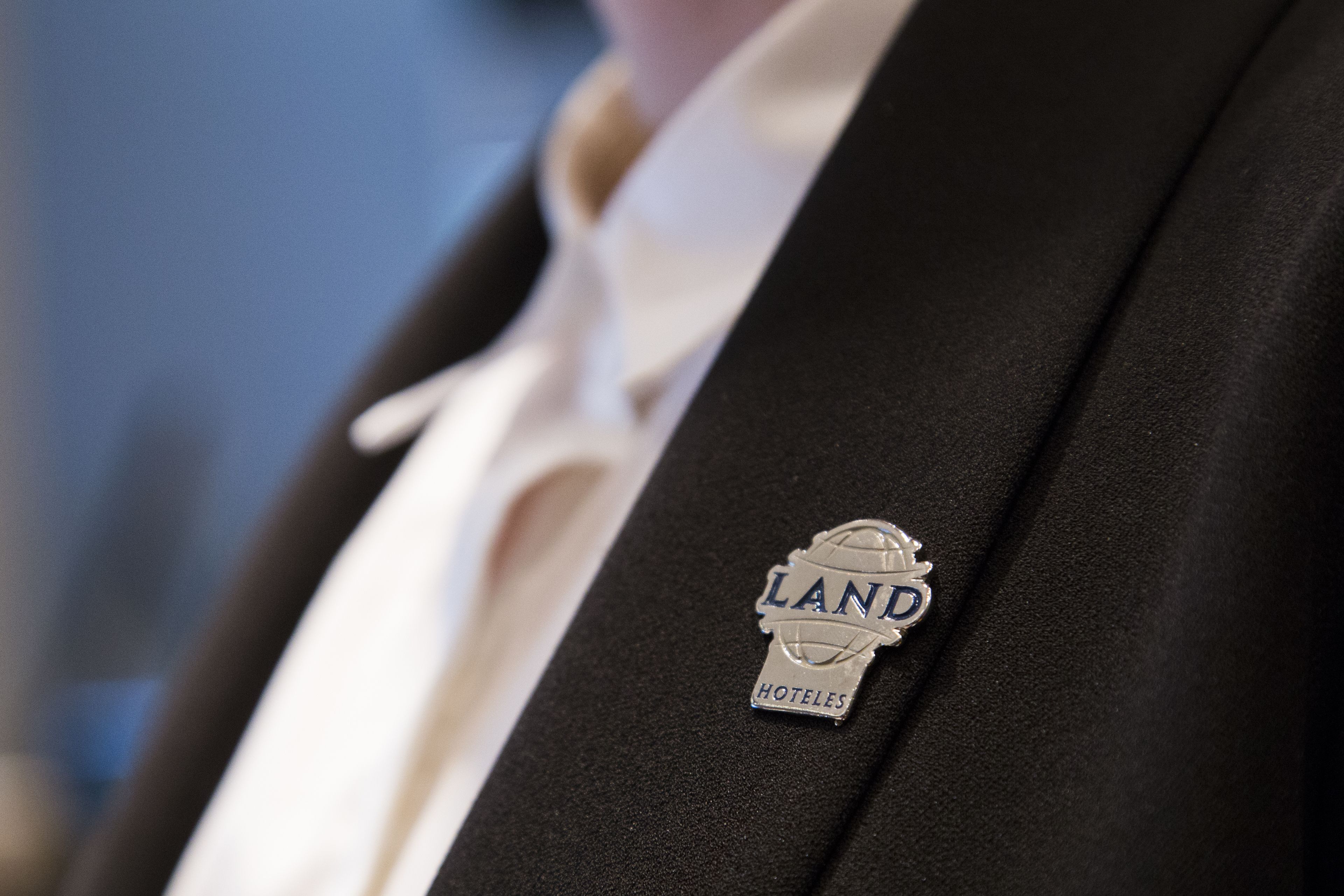 Primer pla d'una insignia amb la paraula 'LAND' i 'HOTELES' escrites.