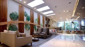 Eine großzügige Lobby mit modernem Design, inklusive einer Couch, Sesseln und einem Couchtisch.