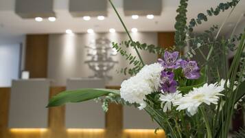 A reception area with a reception desk, a decorative glass sculpture, and a floral arrangement.