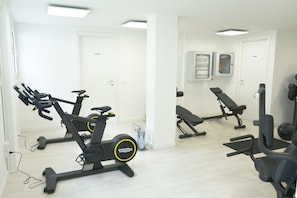 A gym with stationary bikes, a treadmill, and weight machines.