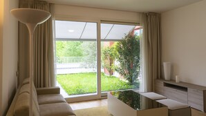 A modern living room with a sofa, a coffee table, and a TV stand. - Apartments Residence Villa Olmo (Como)