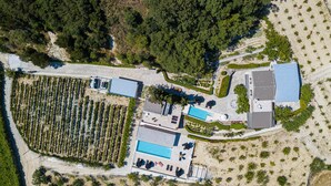 Vue aérienne d’une propriété dotée d’une piscine, d’un espace extérieur couvert et d’un vignoble.